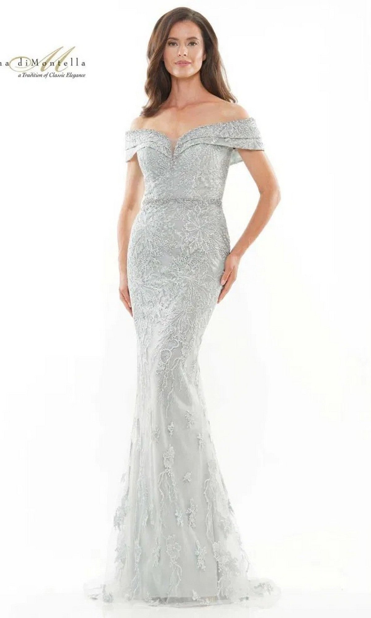 A woman stands against a white background wearing the Rina Di Montella RD2737 long formal dress in Seaglass, featuring an off-the-shoulder design with sheer lace and a beaded waist.
